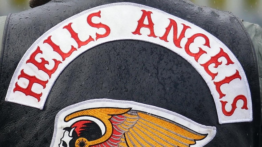 A Hells Angels member waits outside a funeral