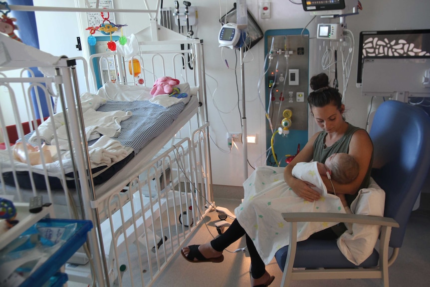 Chelsea Cocking holding daughter Tahlea in a hospital room.