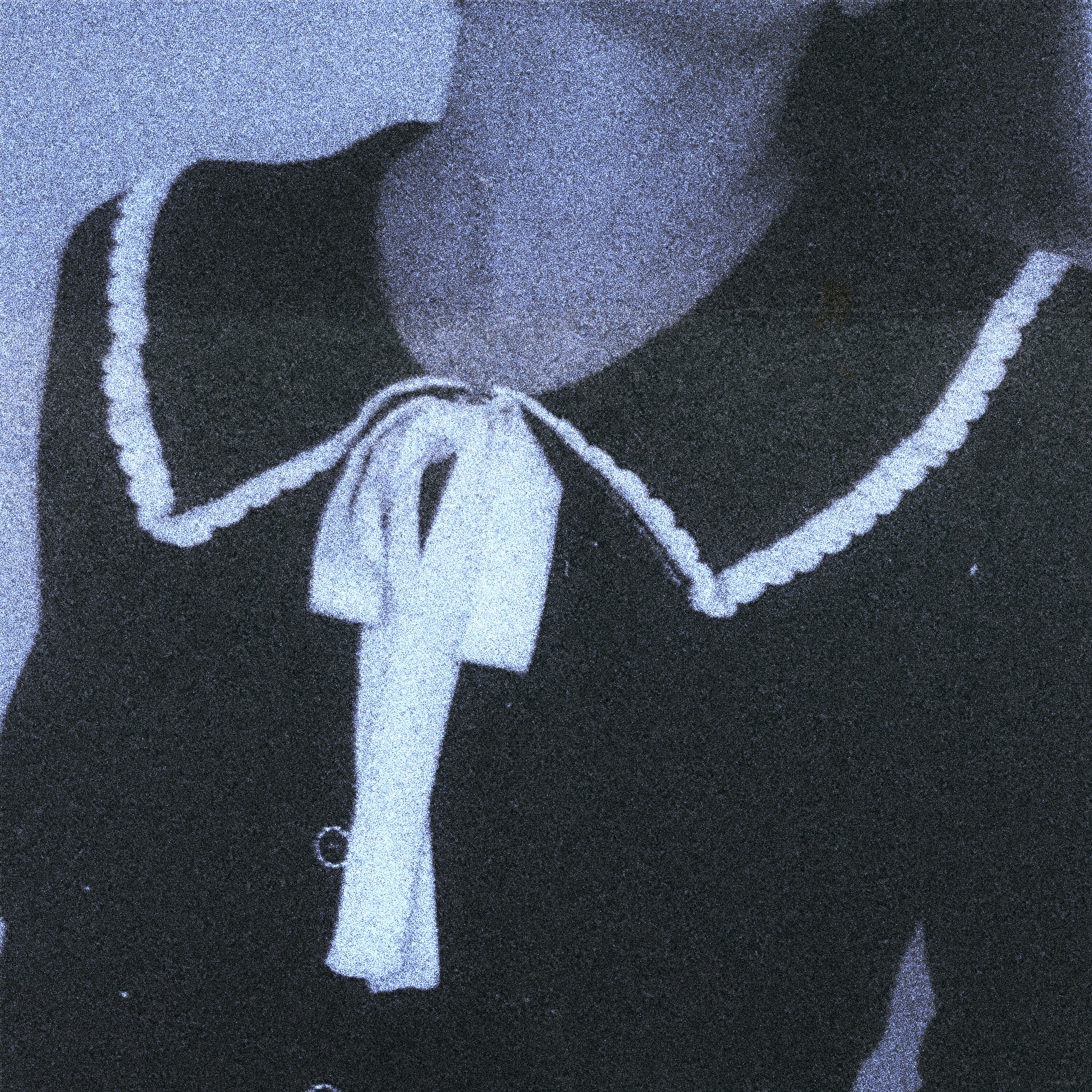 A grainy photo of a frock with lacey bow and collar, cropped with just the torso and shoulders