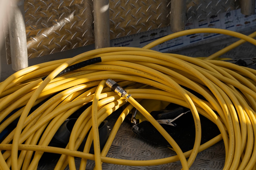 A yellow hose on a boat.
