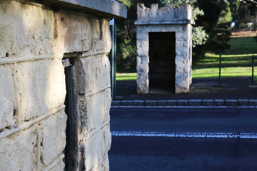 Two stone guardhouses stand either side of the road at Royal Park.