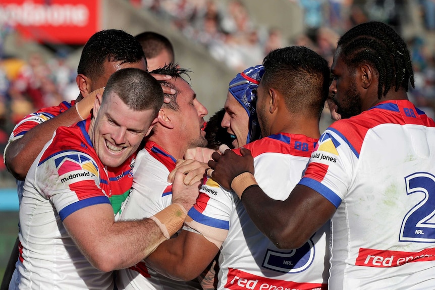 Knights players surround Mitchell Pearce to congratulate him after he scored a try for against the Warriors.