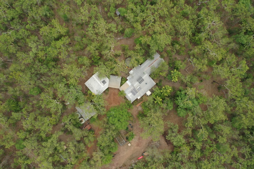 Drone photo of house roof with solar panels in bushland,