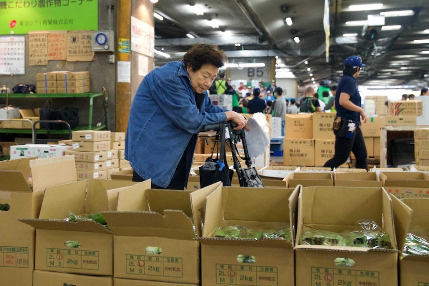 Shigeko Takahashi inspects fresh produce in boxes