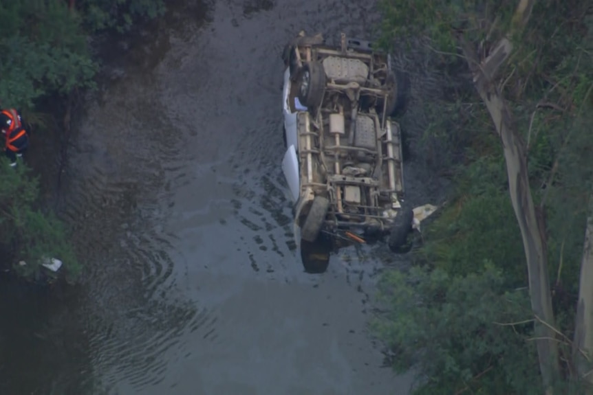 An overturned car in a river 