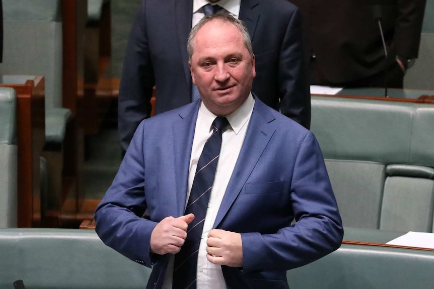 Barnaby Joyce holds the front of his suit jacket, while standing in the House of Representatives