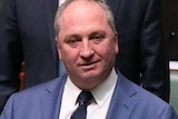 Barnaby Joyce holds the front of his suit jacket, while standing in the House of Representatives