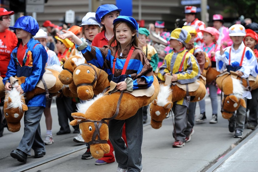 Children dressed up as horses walk down Swanston Street during the Melbourne Cup parade.