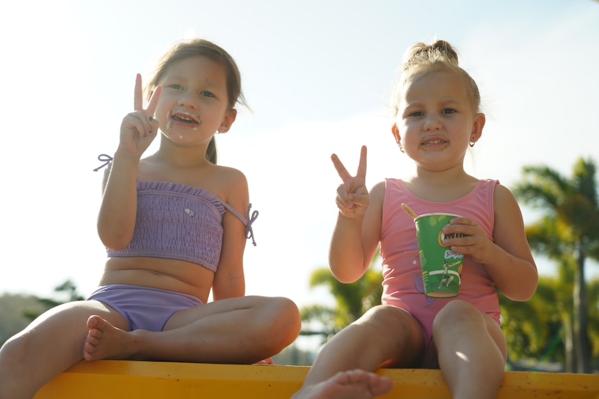 Two little girls eat icecream