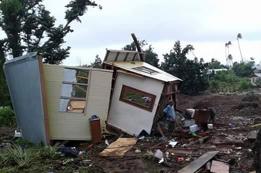 People inspect damaged houses.