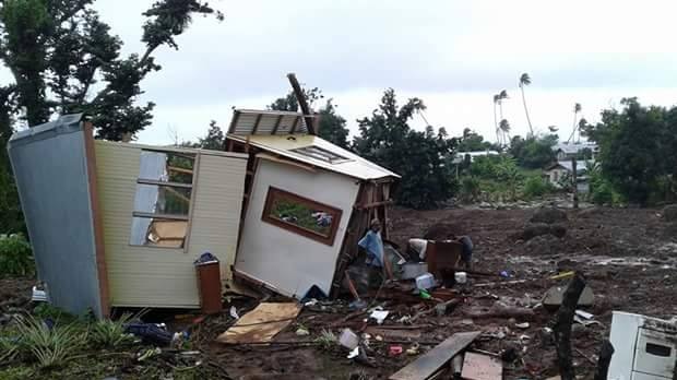 People inspect damaged houses.