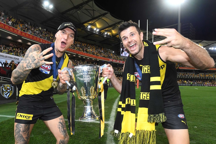 Dustin Martin and Trent Cotchin hold the AFL trophy while doing a lap of honour after the grand final win over Geelong