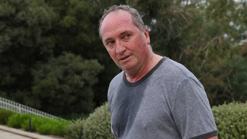 Barnaby Joyce, sweaty and red in the face, turns to look behind him. He is wearing sports attire.