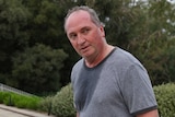 Barnaby Joyce, sweaty and red in the face, turns to look behind him. He is wearing sports attire.