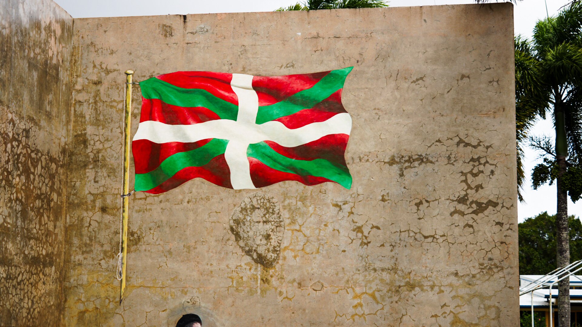 The red, white and green Basque flag painted on the handball court wall.