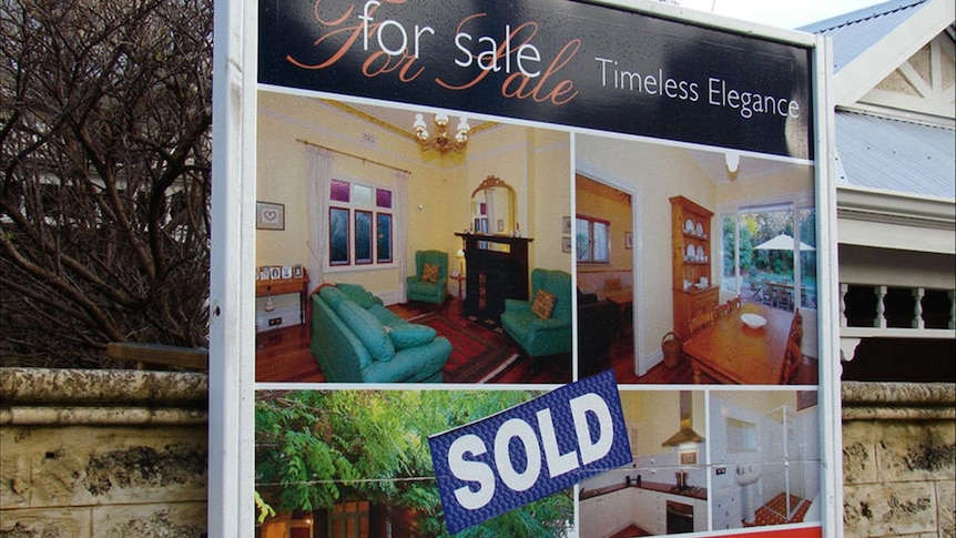 Close-up of an auction sign, with a "sold" sticker covering the sign.