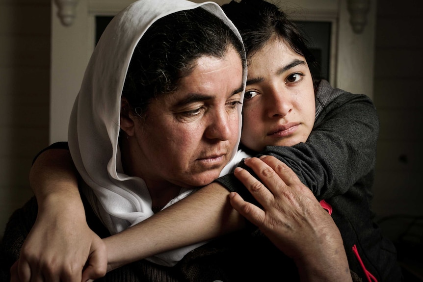 A mother and daughter hugging.