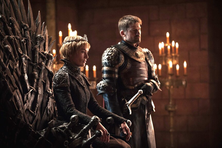 Jaime stands beside Cersei, who sits on the Iron Throne