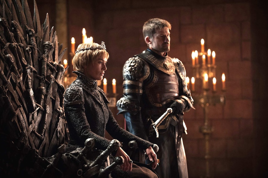 Jaime stands beside Cersei, who sits on the Iron Throne