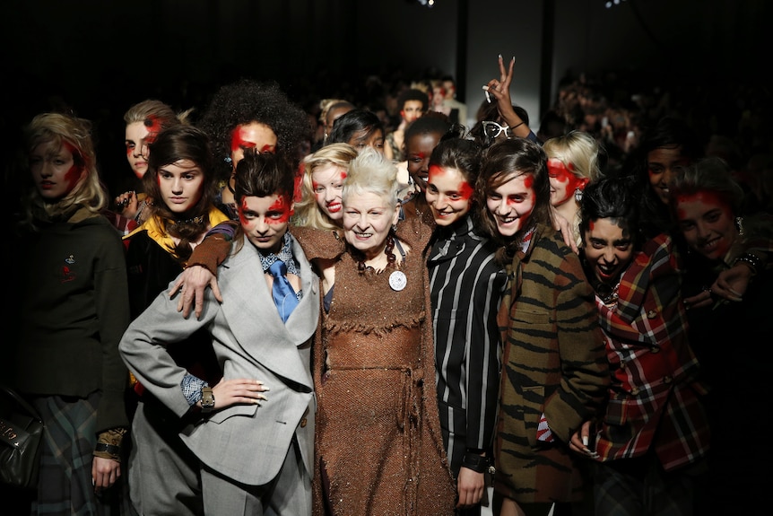 Vivienne Westwood stands with models in suits 