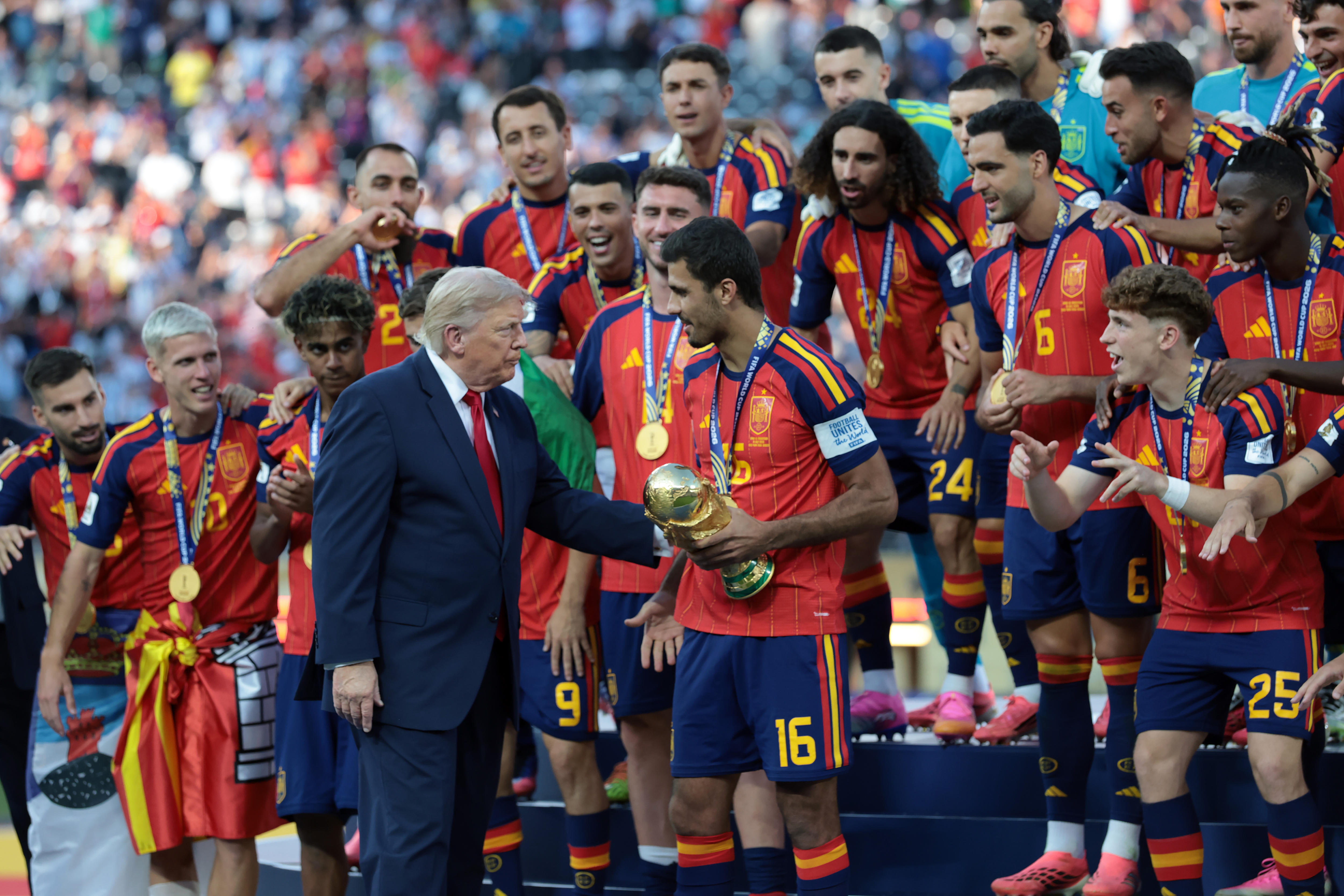 Donald Trump stands near Spain's players as Rodri waits and holds the World Cup