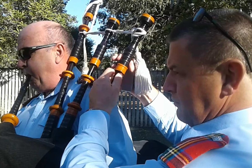 James Kelso adjusting the tuning on a piper's bagpipes