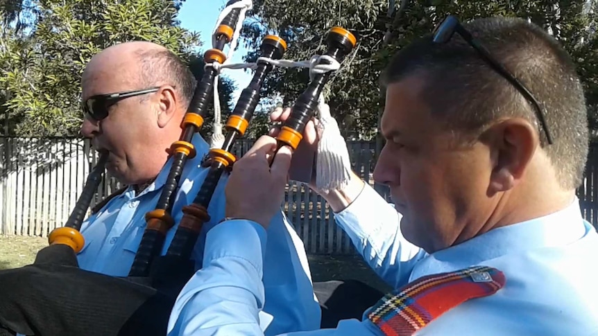 James Kelso adjusting the tuning on a piper's bagpipes