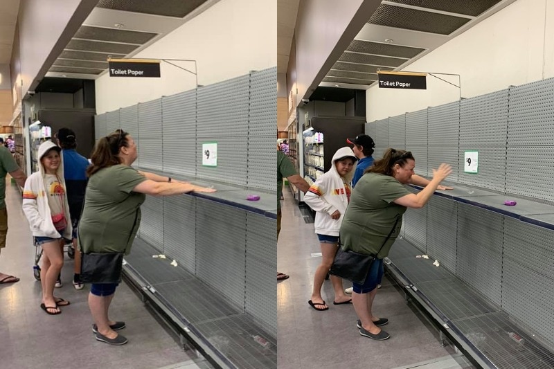 A woman looks sad at the sight of the empty shelves, a sign says 'toilet paper.'