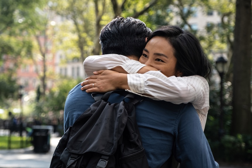 Actors Greta Lee and Teo Yoo hug in a scene from the film Past Lives.