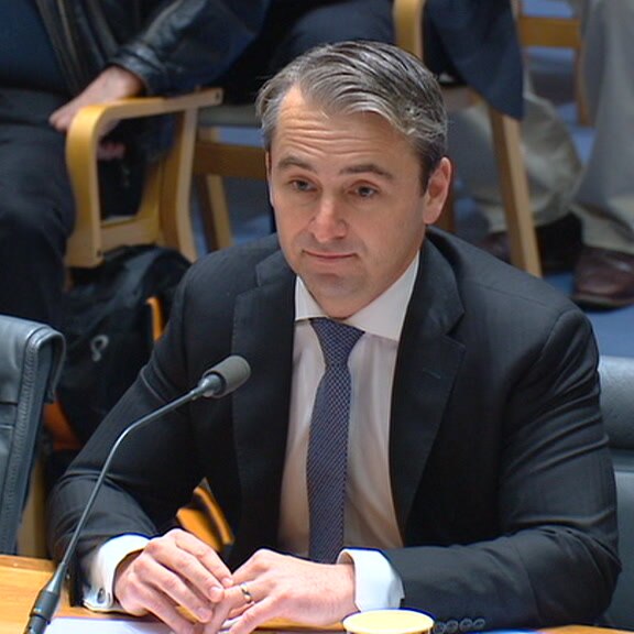 Commonwealth Bank chief executive Matt Comyn seated in front of microphone.