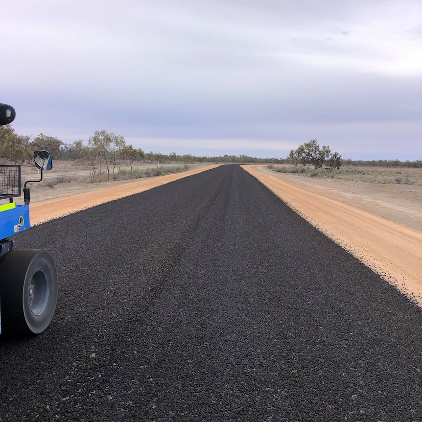 Bitumen is laid on a dirt road in between Menindee and Pooncarie. 