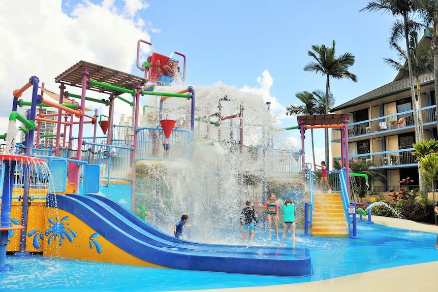 Children play in a brightly coloured water park.