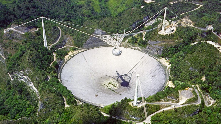 A distant view from above the Arecibo telescope among mountains and forest