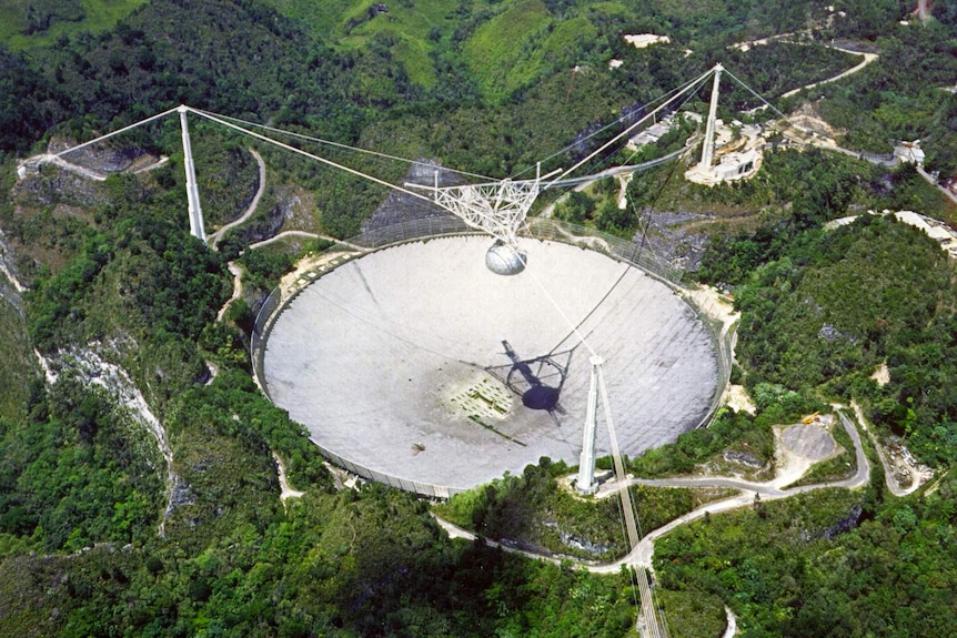 A distant view from above the Arecibo telescope among mountains and forest