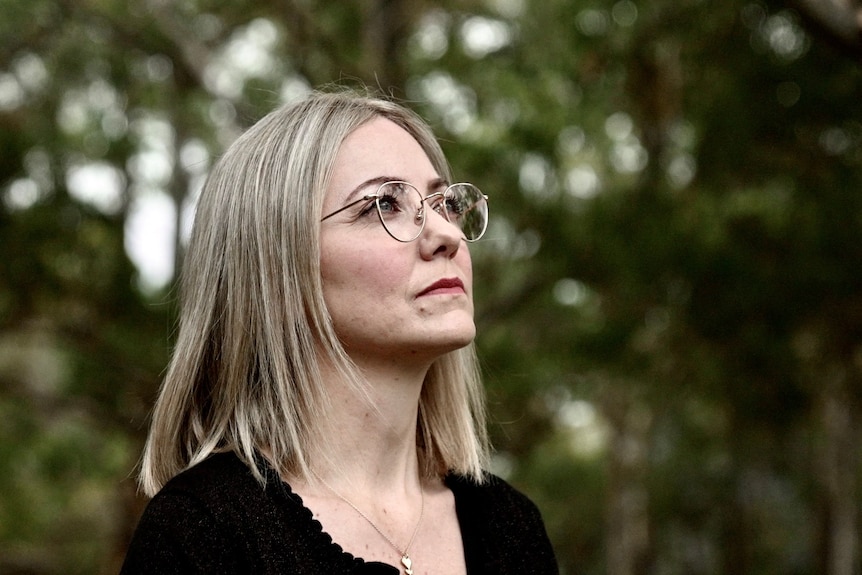 Sharon Draper standing in a park in Sydney staring out to the distance. 