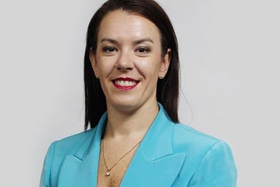 a woman wearing a blazer looking and smiling