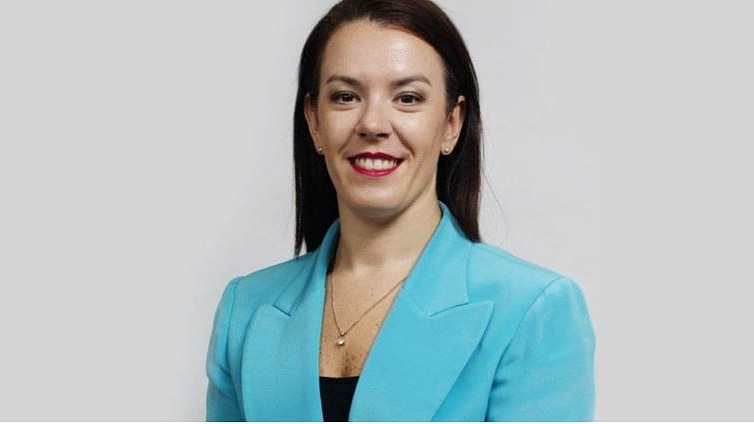 a woman wearing a blazer looking and smiling