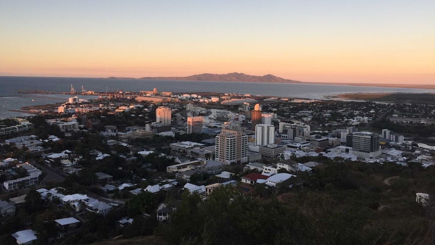 An aerial view of the Townsville central business district, port and coast as the sun sets.