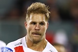 St George Illawarra Dragons player Jack de Belin passes a football. Teammate Andrew McCullough is blurred behind him.