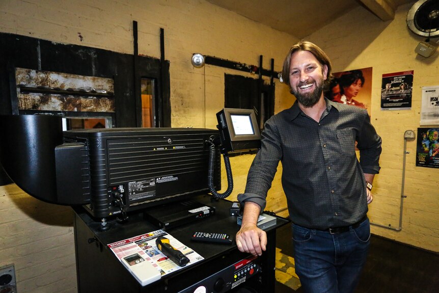 Business manager Martin Myles with the $70,000 digital projector that replaced the old reels.