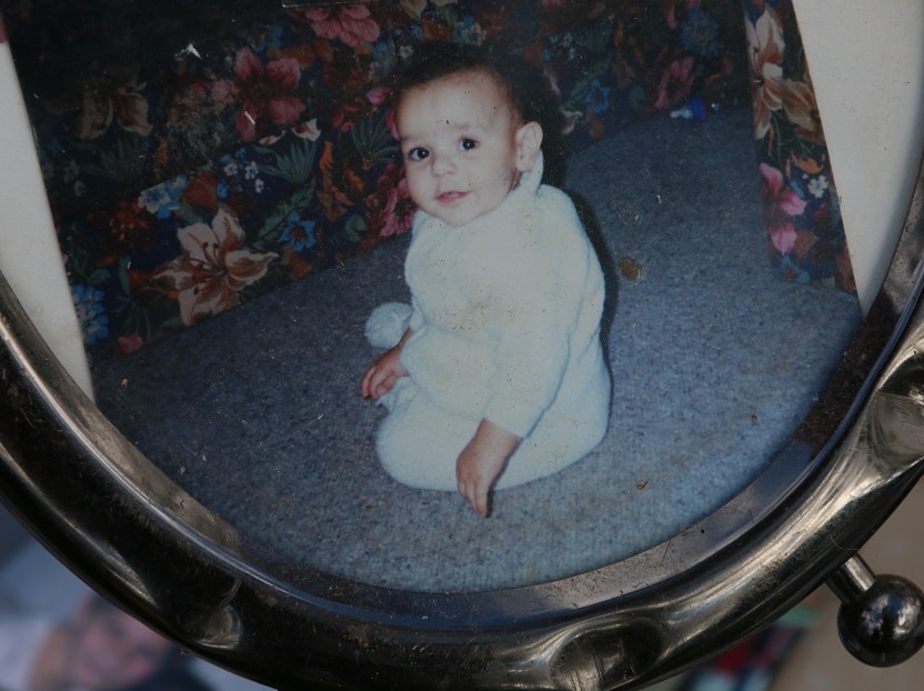 A photo of a baby in metal frame.