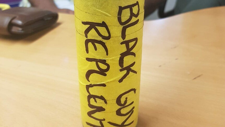 Cannister with yellow tape and the words 'BLACK GUY REPLLENT' that a man says he was given at work.