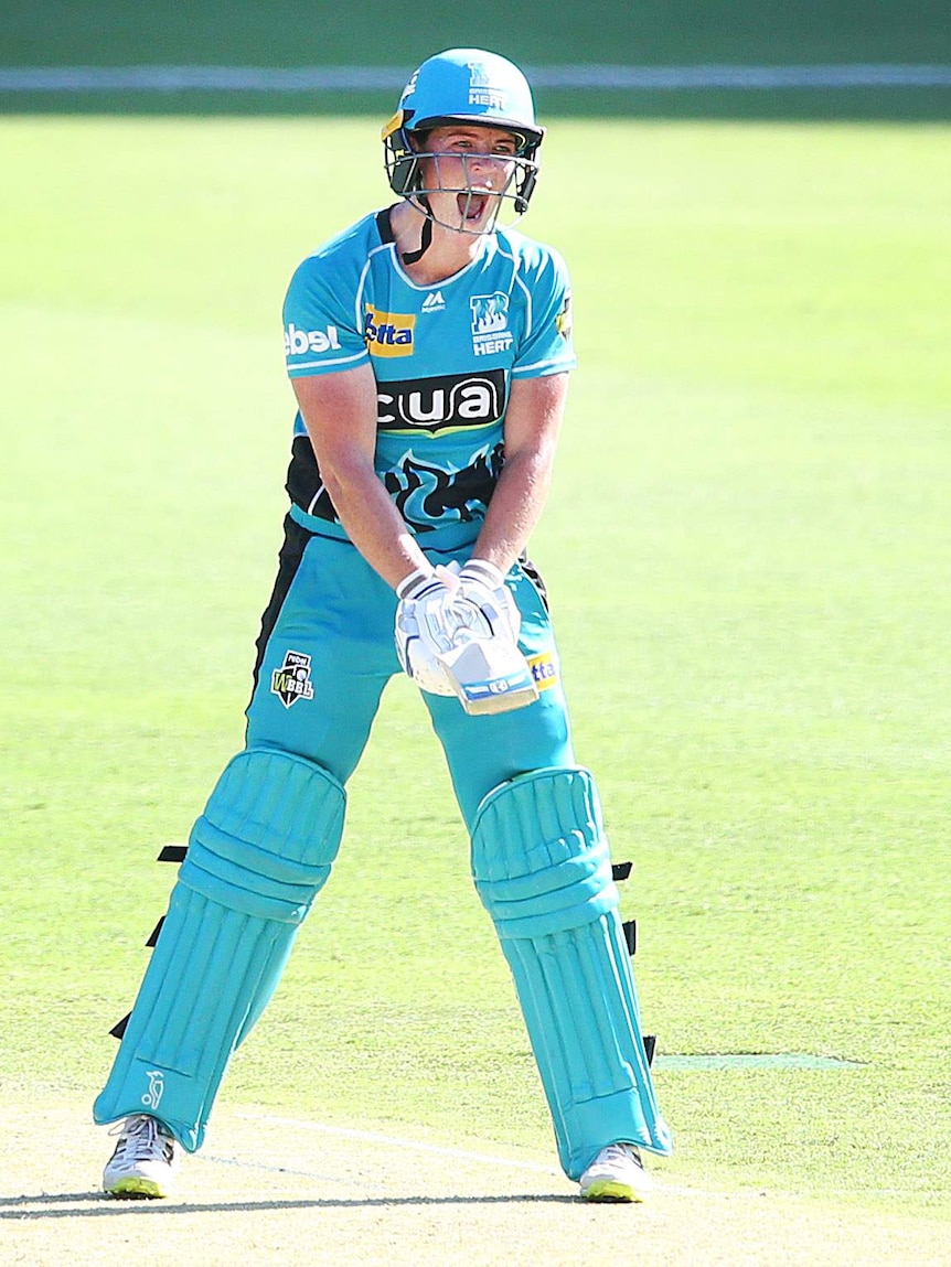 Grace Harris yells out after hitting a six to bring up her century for the Heat.