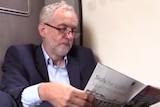 A still from the video of Jeremy Corbyn sitting on a train floor.