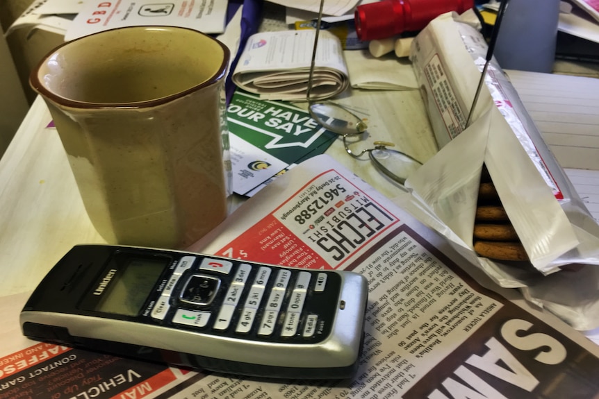 Cordless phone on messy kitchen table