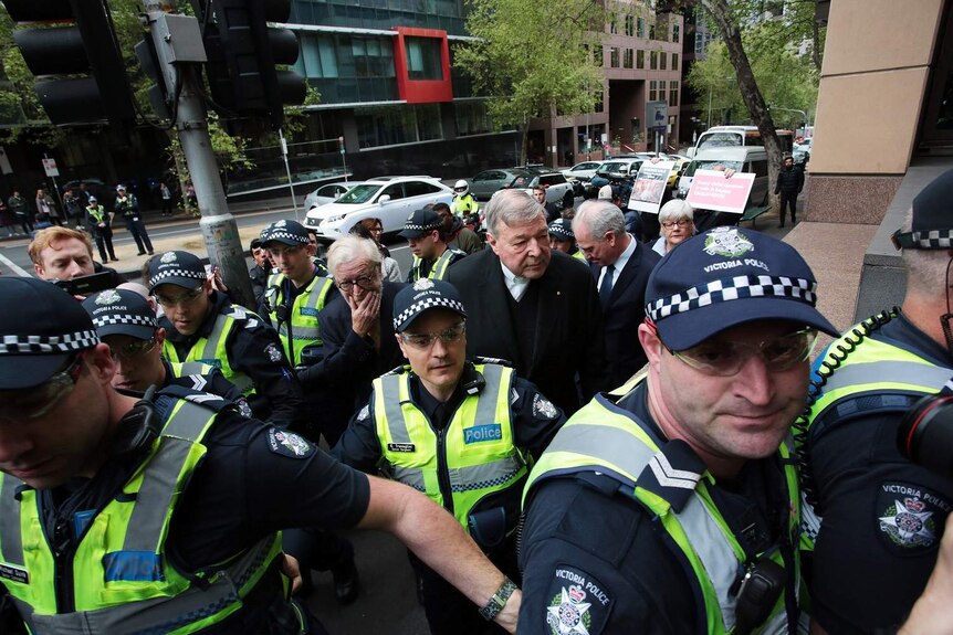 Cardinal George Pell escorted by police arrives at the Melbourne Magistrates' Court.
