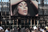 People walk past a billboard ad featuring Kim Kardashian