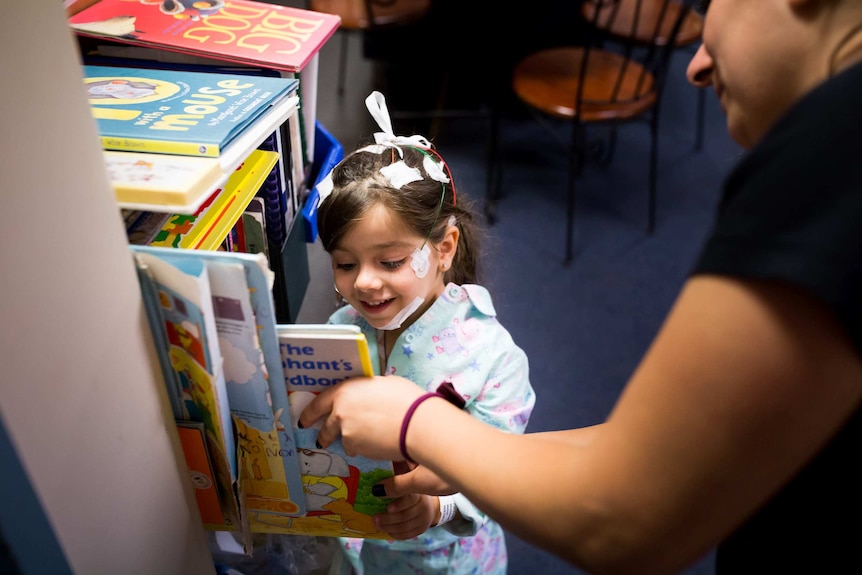 Melina picking a book to read before bedtime.