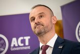 Andrew Barr speaks at a podium with ACT Government branding,