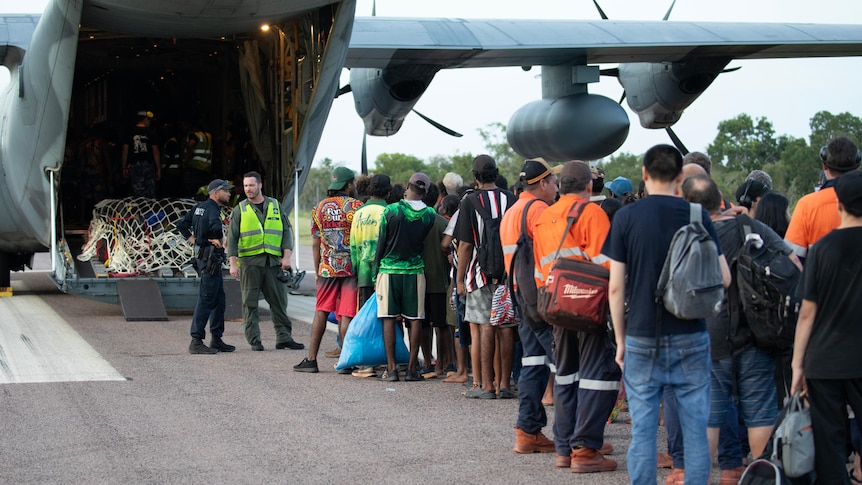 Royal Australian Air Force aviators assist Borroloola remote community members board a C-130J Hercules aircraft at the airport.